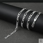 Silver figaro chain on a dark surface