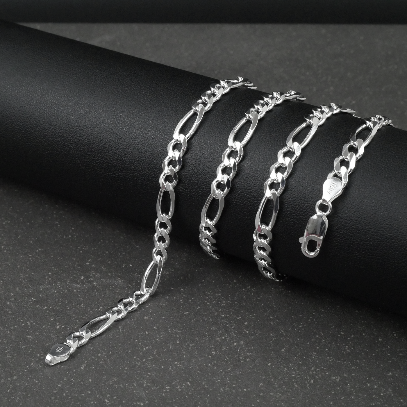 Silver figaro chain on a dark surface