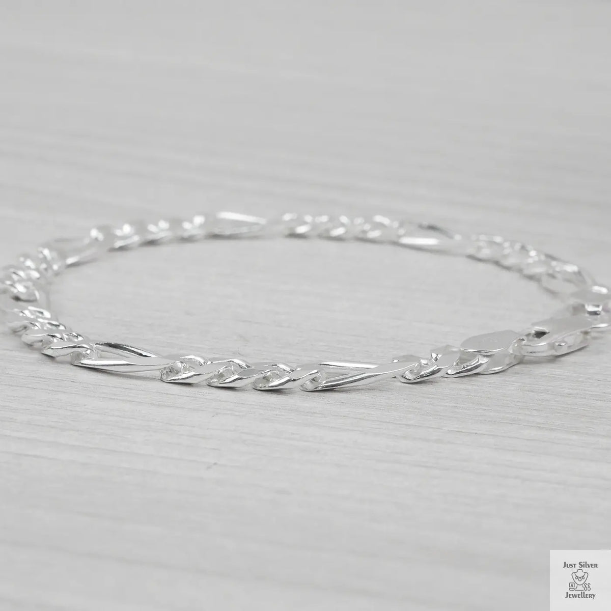 Silver bracelet on a light grey background