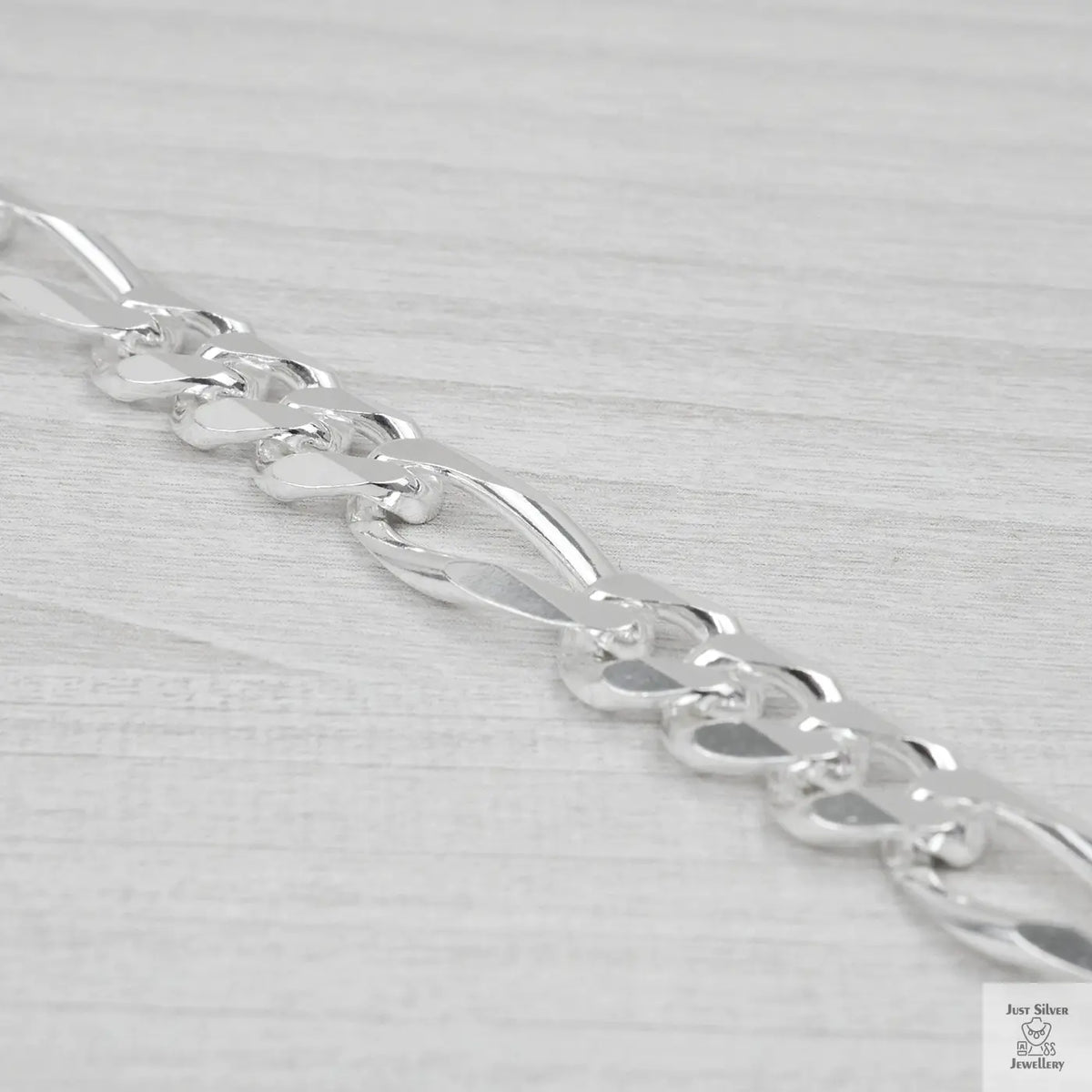 Silver bracelet on a light grey background