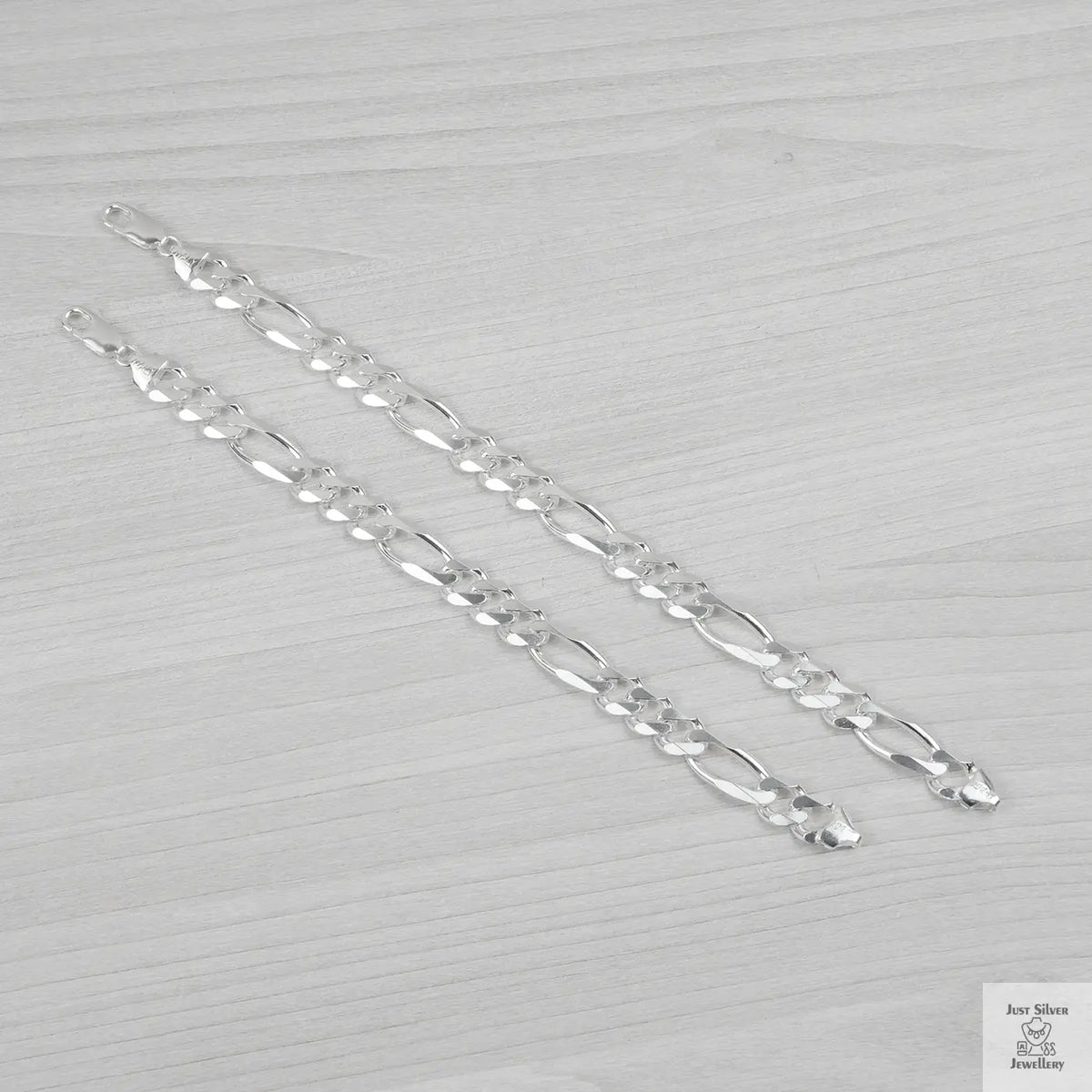 Silver bracelets on a light grey background