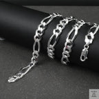Silver figaro chain on a dark surface