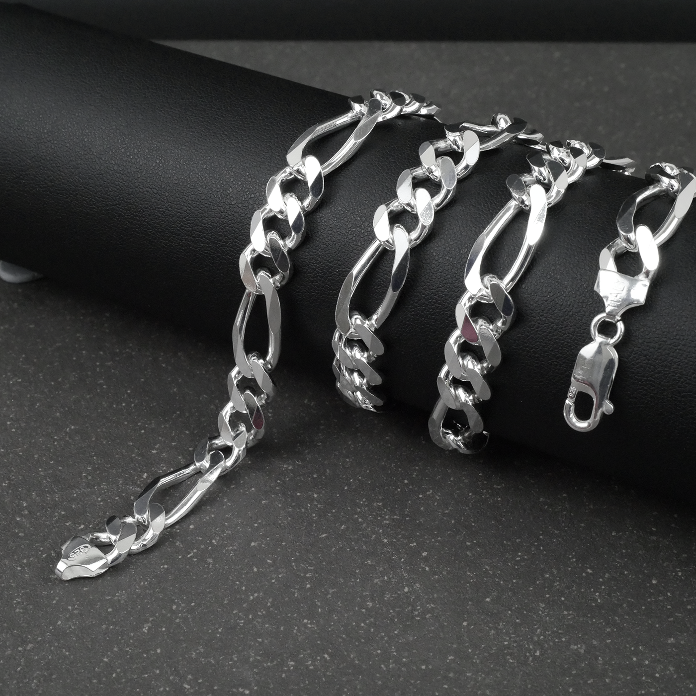 Silver figaro chain on a dark surface