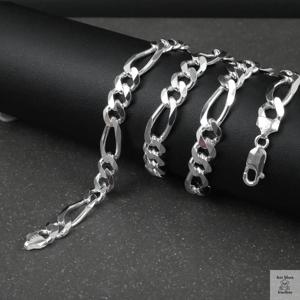 Silver figaro chain on a dark surface