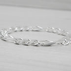 Silver bracelet on a light grey background