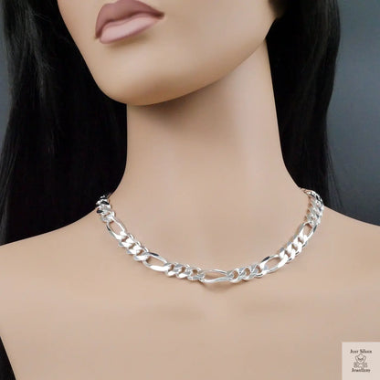 Silver figaro chain necklace on a mannequin with a plain background