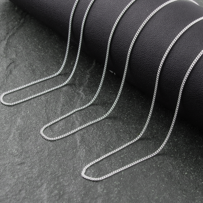 Silver chain on a dark textured surface
