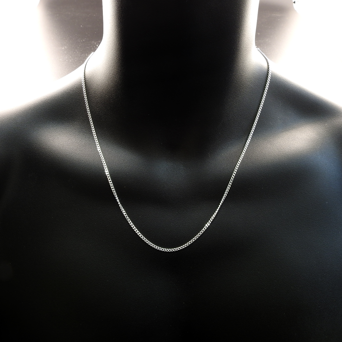 Silver chain necklace on a black mannequin