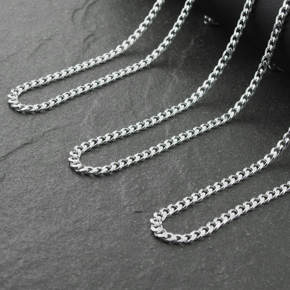 Silver chain necklace on a dark stone surface