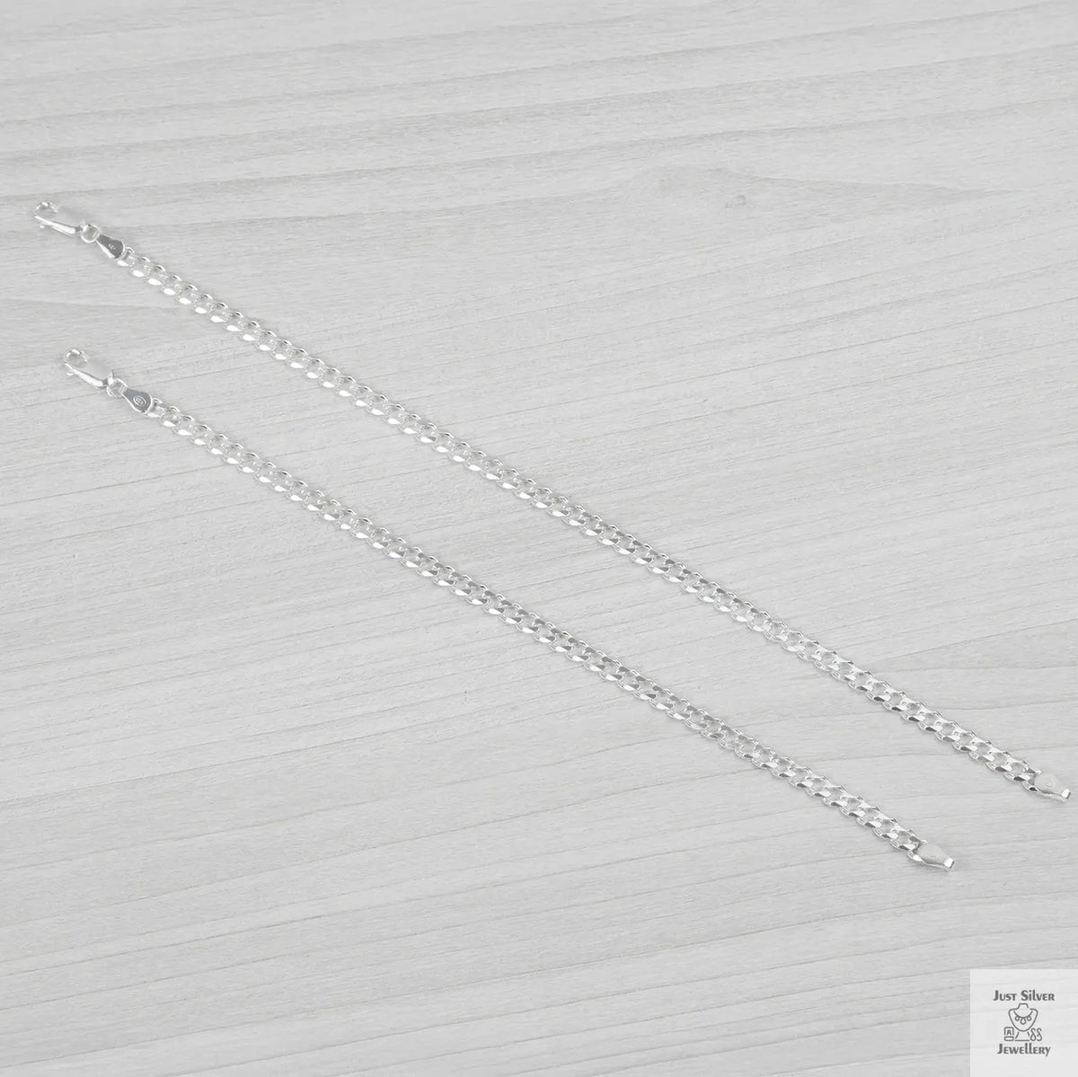 Silver bracelets on a textured grey surface