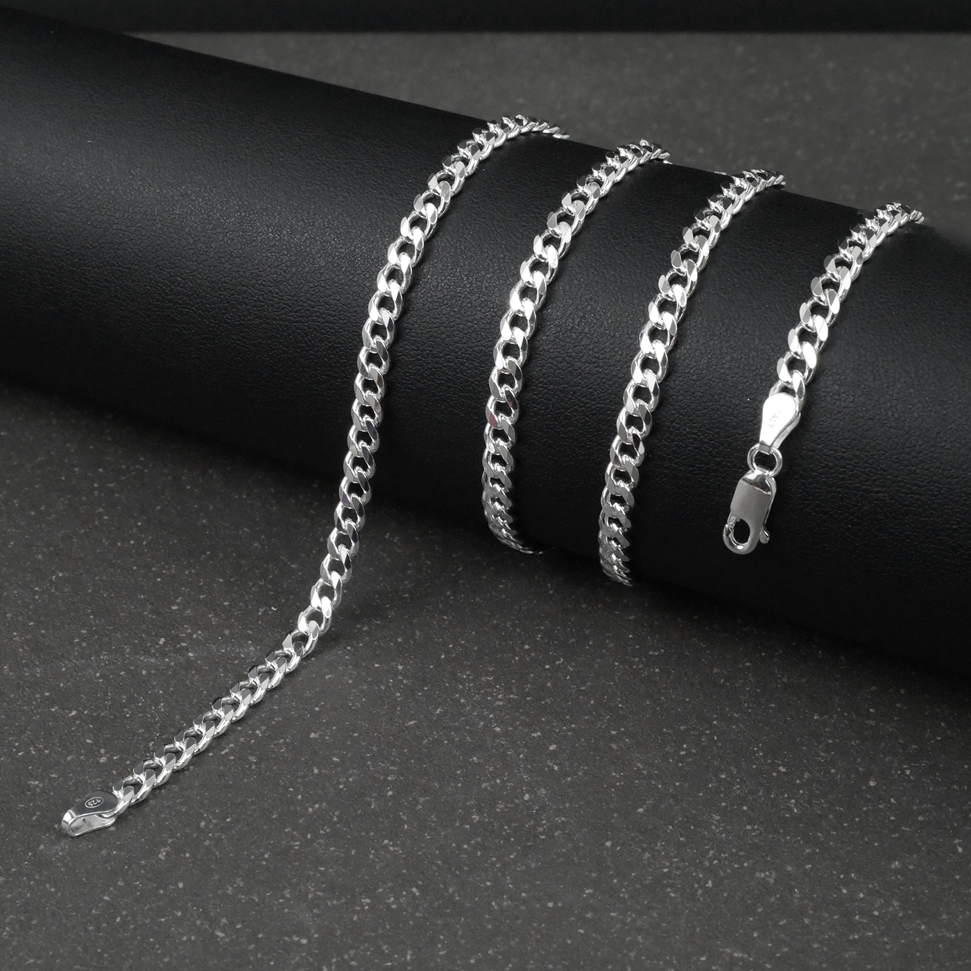 Silver curb chain on a dark surface
