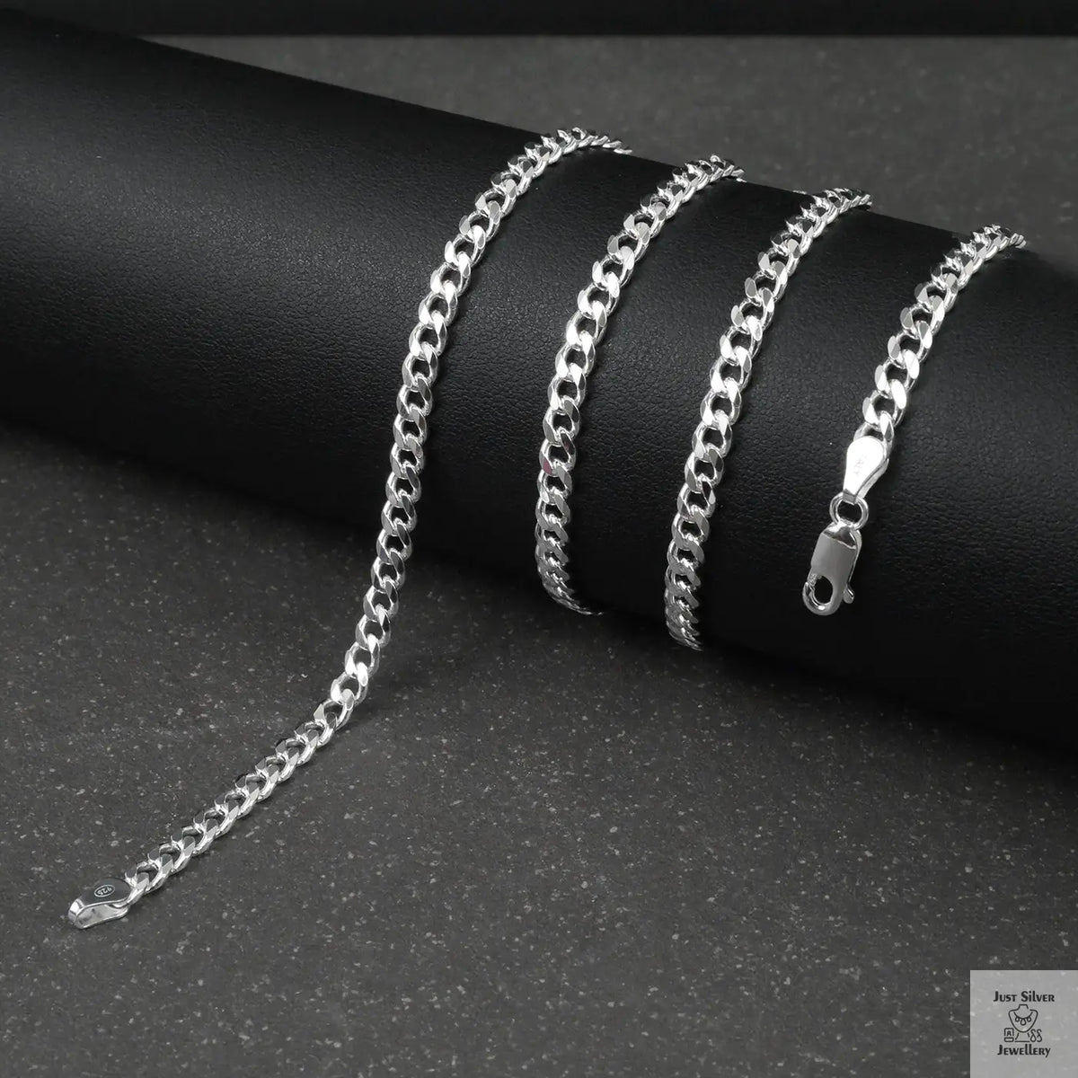 Silver curb chain on a dark surface