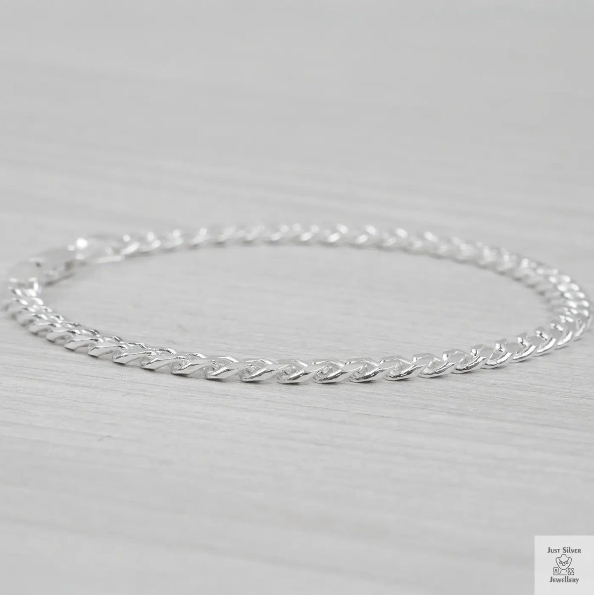 Silver curb bracelet on a light gray background