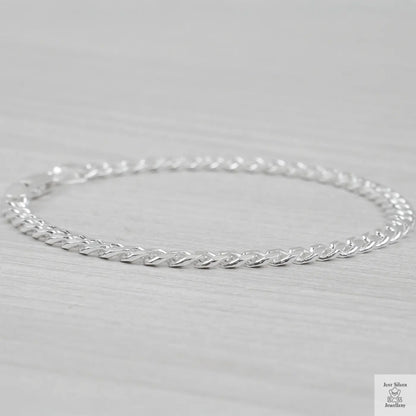 Silver curb bracelet on a light gray background