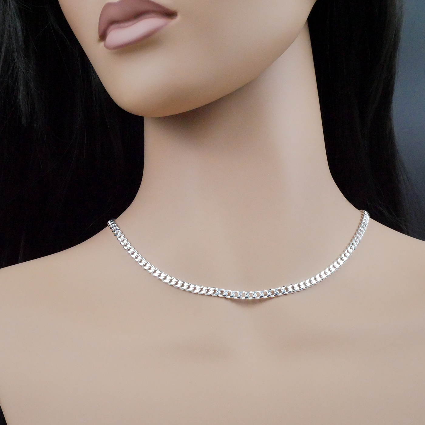Silver chain necklace on a mannequin with a dark background