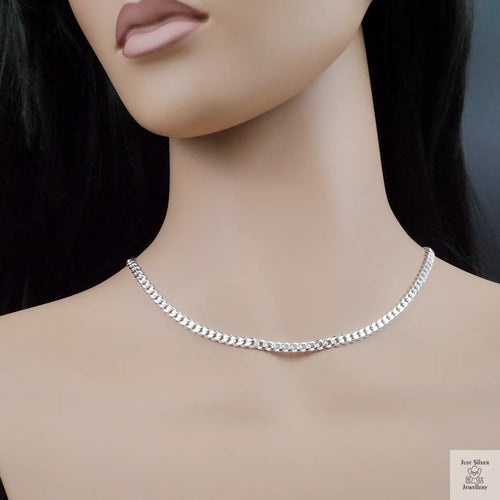 Silver chain necklace on a mannequin with a dark background