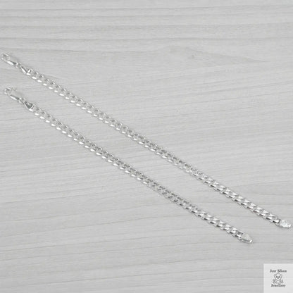 Silver bracelets on a light grey textured background