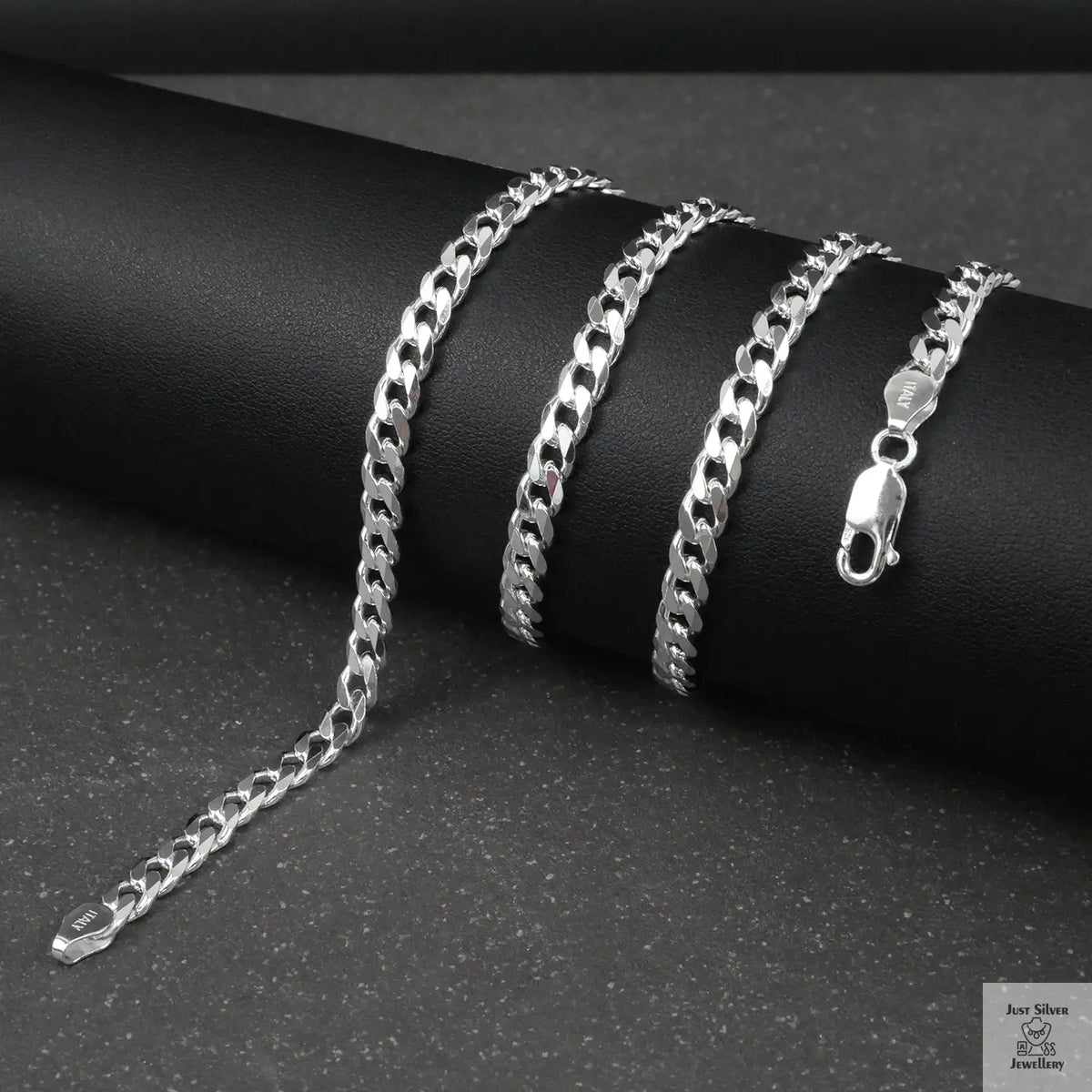 Silver curb chain on a dark surface