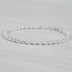 Silver bracelet on a light grey background