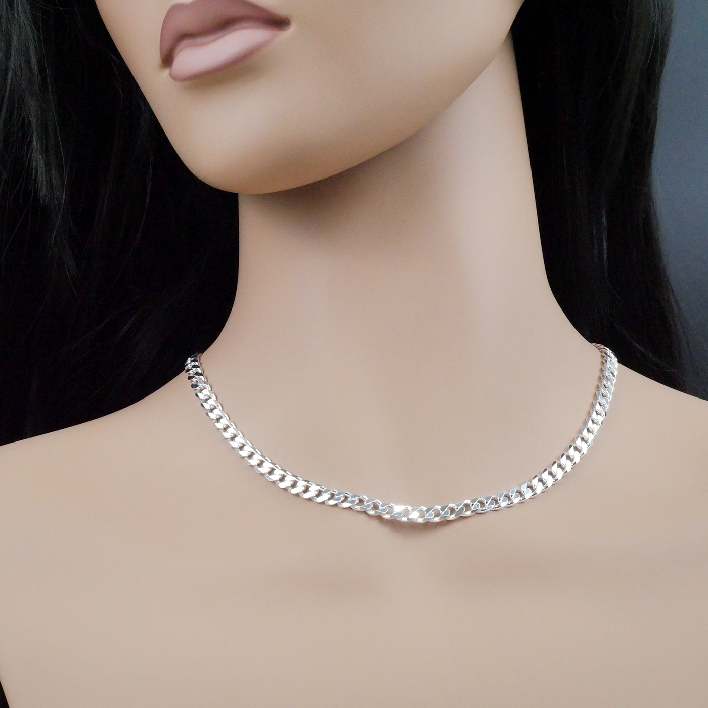 Silver chain necklace on a mannequin with a plain background