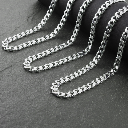 Silver chain necklace on a dark stone surface