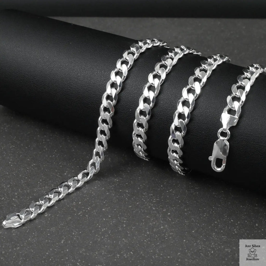 Silver curb chain on a dark surface