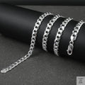 Silver curb chain on a dark surface