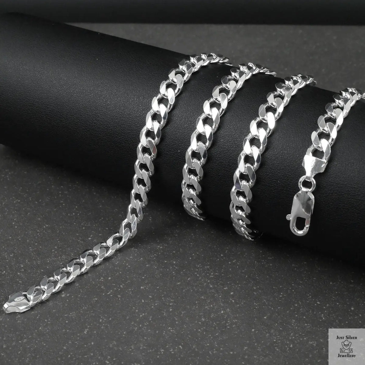 Silver curb chain on a dark surface