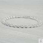 Silver bracelet on a light grey background