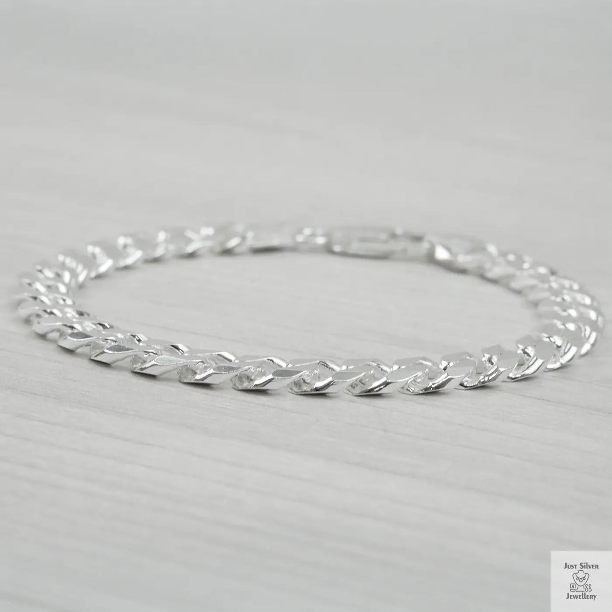 Silver bracelet on a light grey background