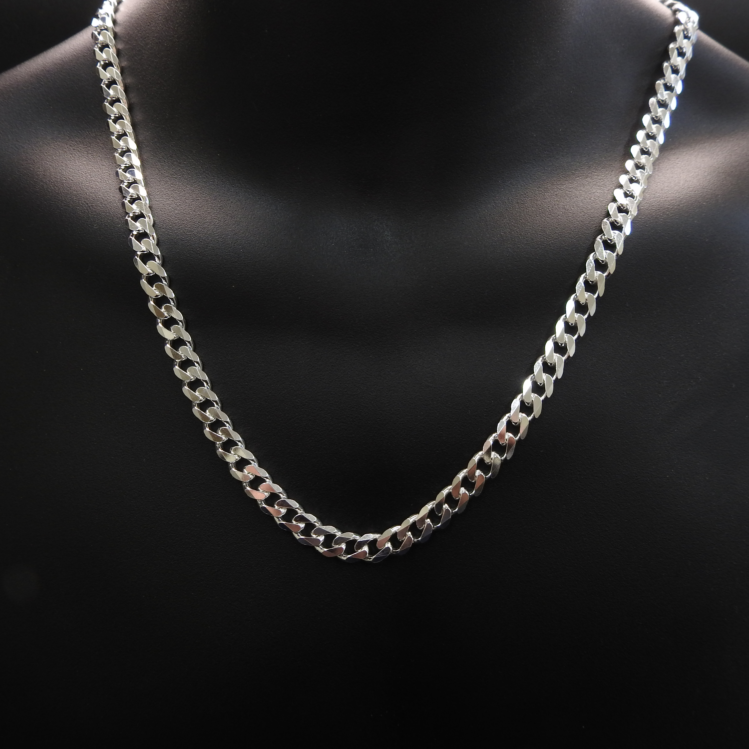 Silver chain necklace on a black mannequin bust.