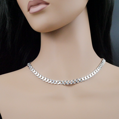 Silver curb chain necklace on a mannequin with a dark background