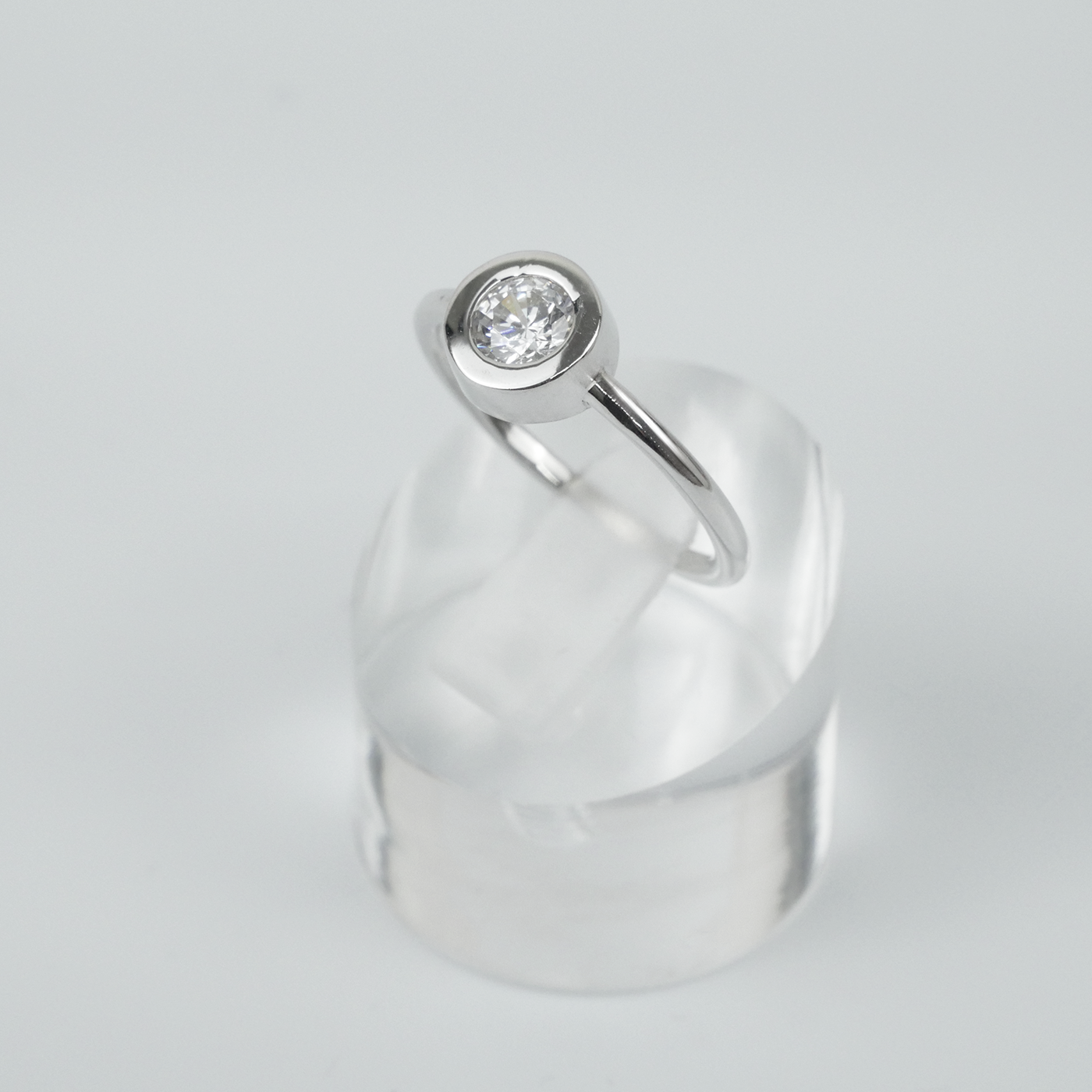 Silver ring with a CZ on a light gray background