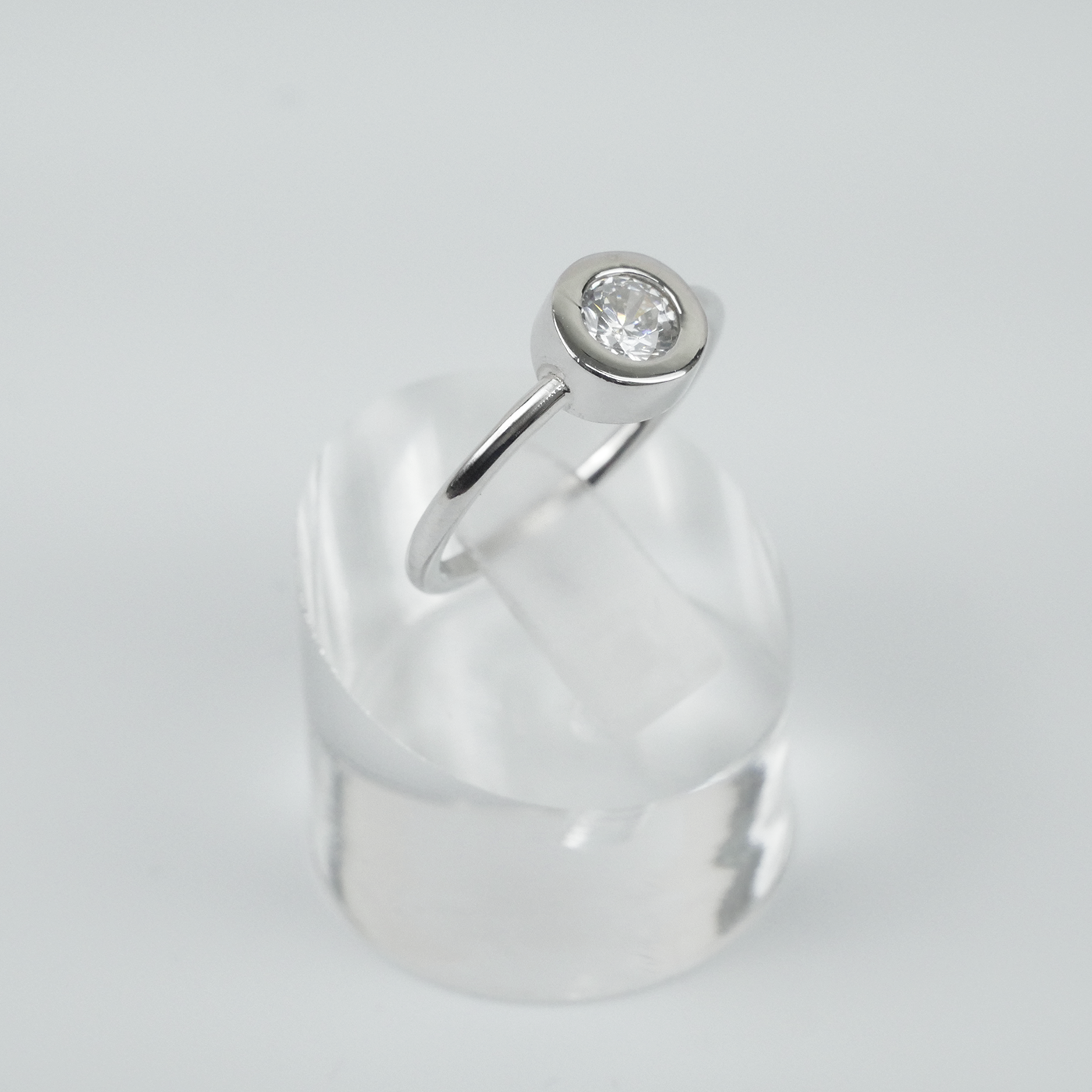 Silver ring with a CZ on a white background