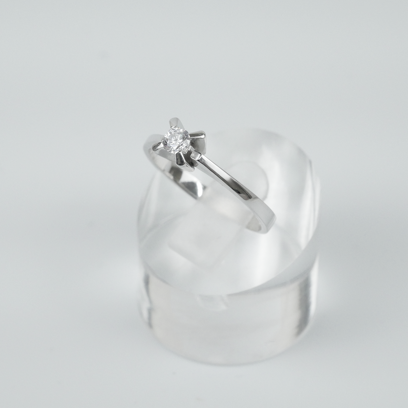 Silver ring with a CZ on a light gray background