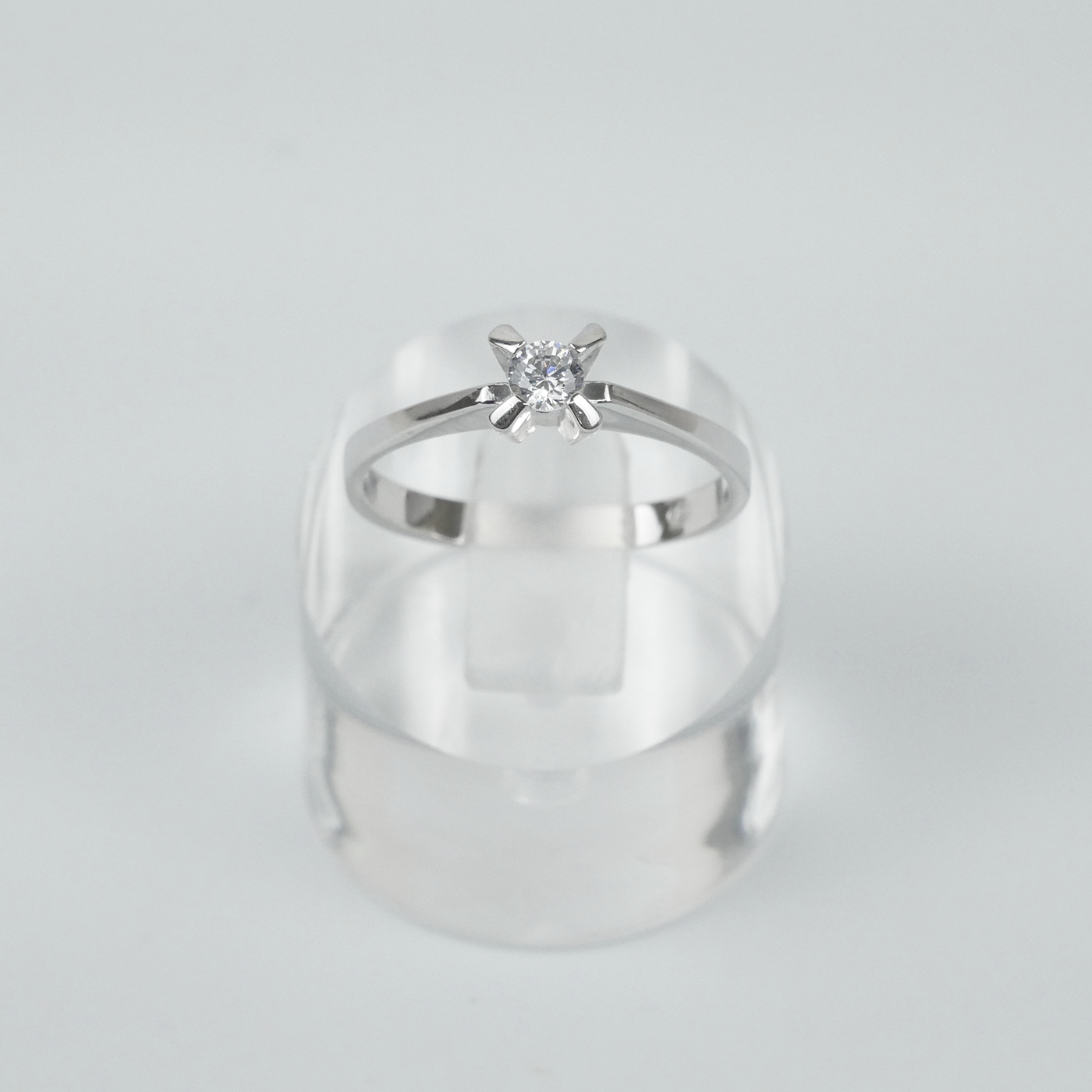 Silver ring with a CZ on a light gray background