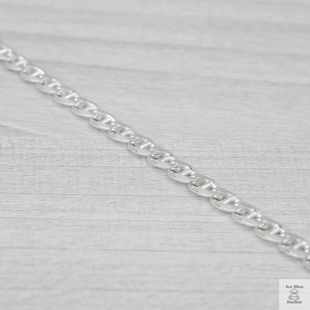 Silver marina link chain on a light grey fabric background
