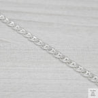 Silver marina link chain on a light grey fabric background