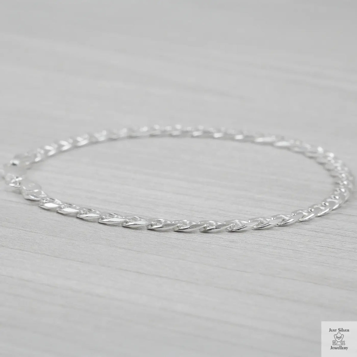 Silver marina link bracelet on a light gray background