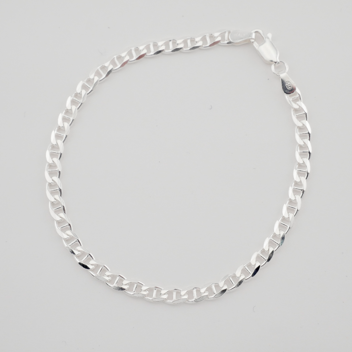 Silver chain necklace on a light gray background