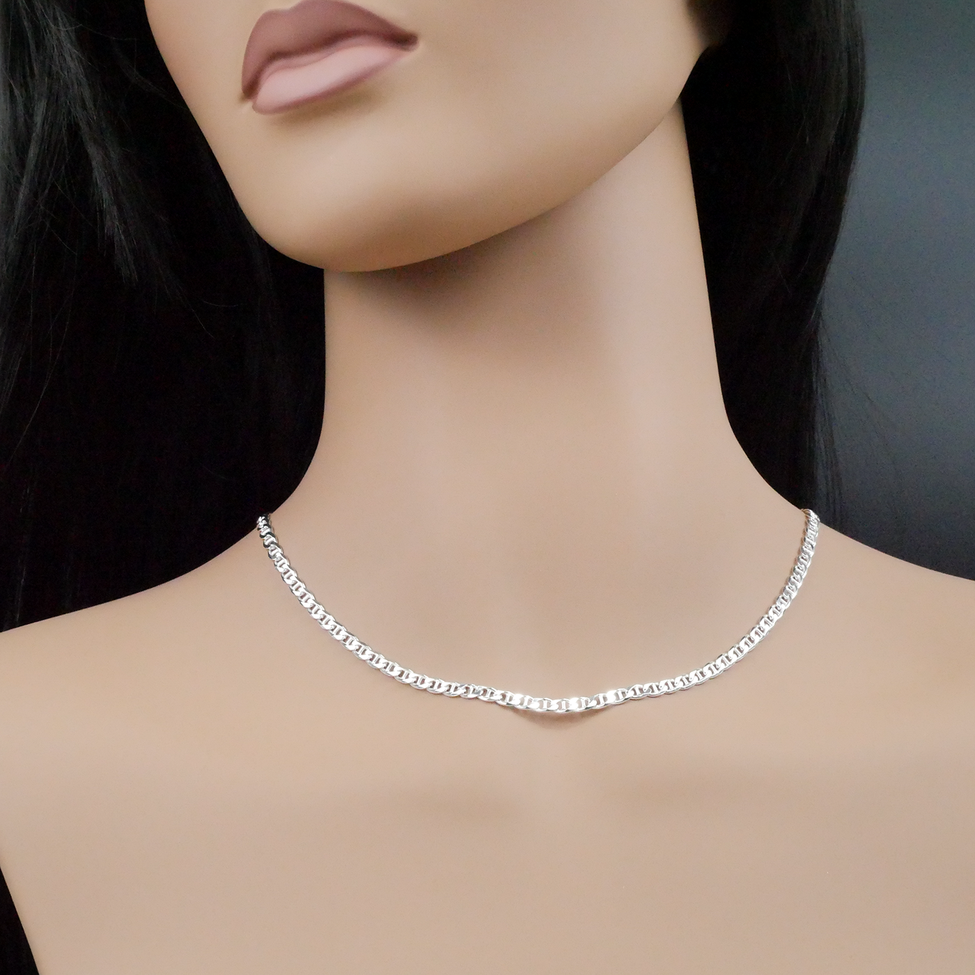 Silver necklace on a mannequin with a dark background