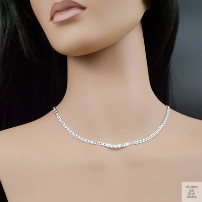 Silver necklace on a mannequin with a dark background