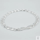 Silver chain bracelet on a light grey background