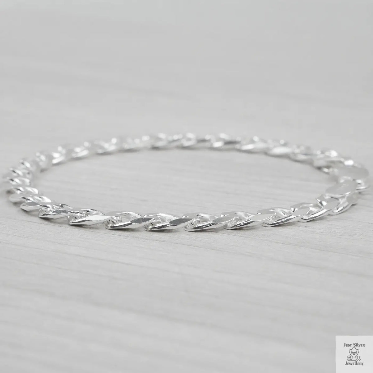 Silver bracelet on a light grey background