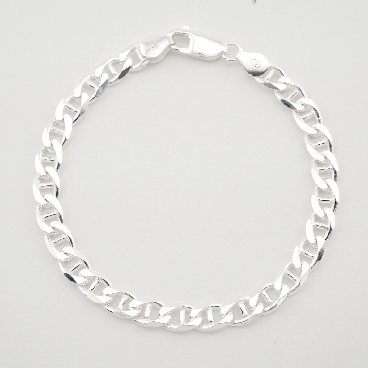 Silver chain bracelet on a light gray background