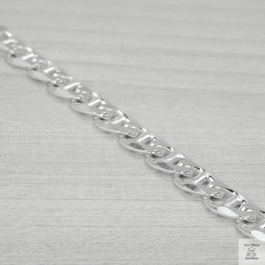 Silver chain bracelet on a light grey background