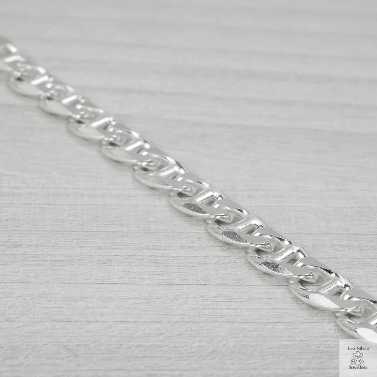Silver chain bracelet on a light grey background