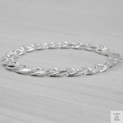 Silver bracelet on a light grey background