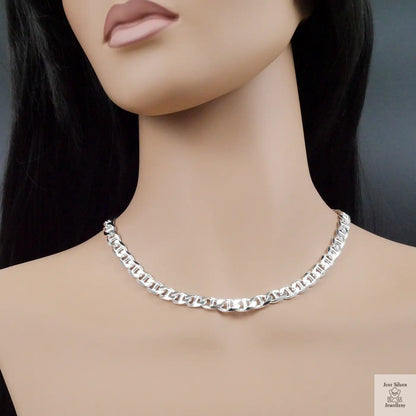 Silver chain necklace on a mannequin with a plain background