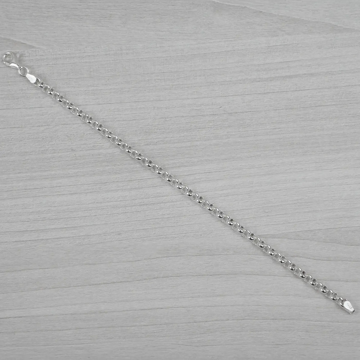 Silver bracelet on a grey textured surface